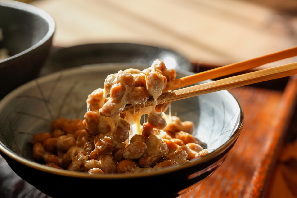 cos'è il natto A scene on the verge of stirring Fermented soybeans in a small bowl and putting it on rice with chopsticks.