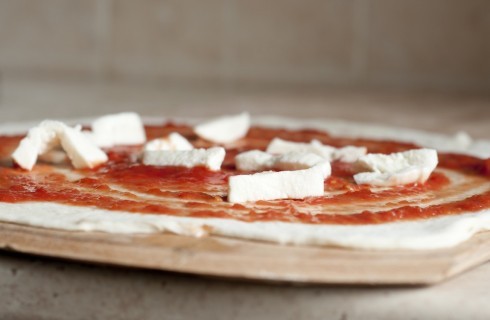 La pizza romana condita con pomodoro e mozzarella