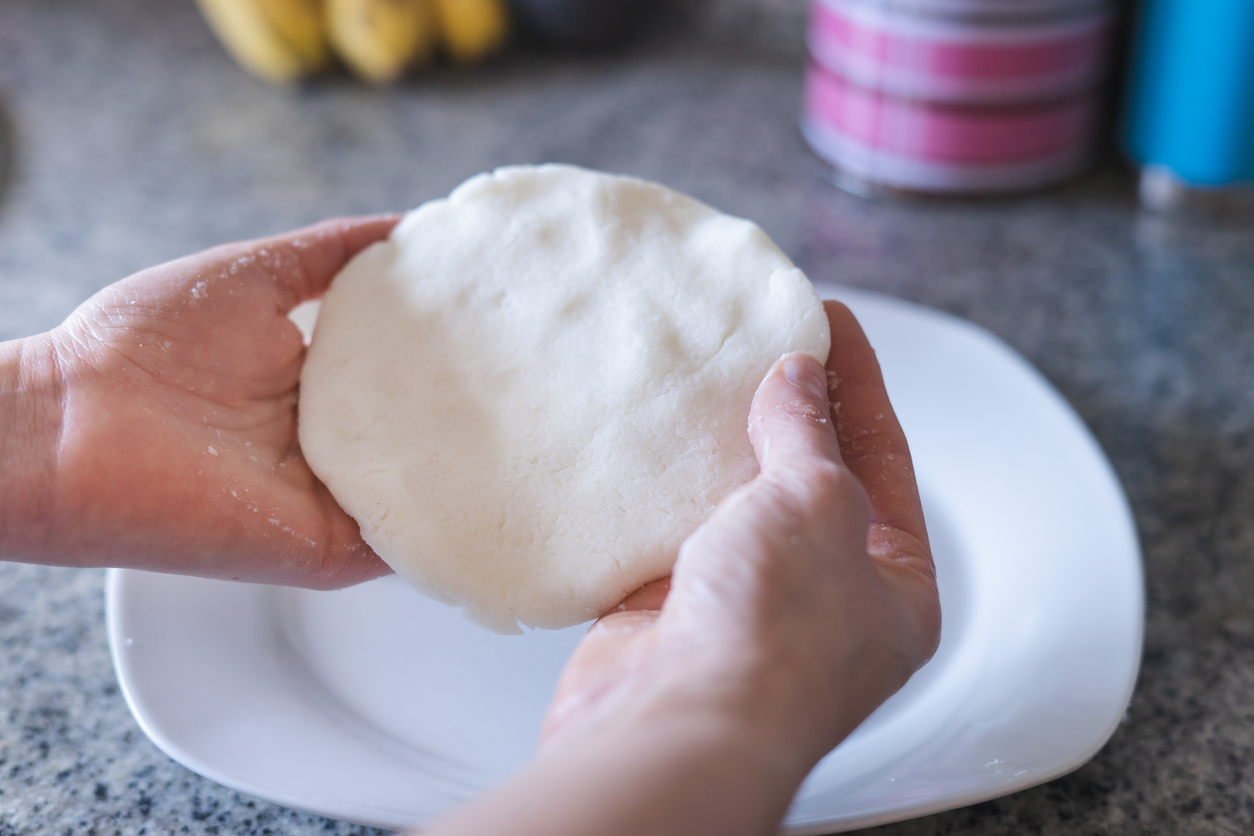 arepa Woman hands making arepas in the kitchen. Latin food.