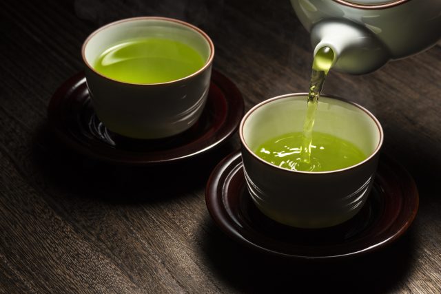 Versare tè verde nelle tazze
