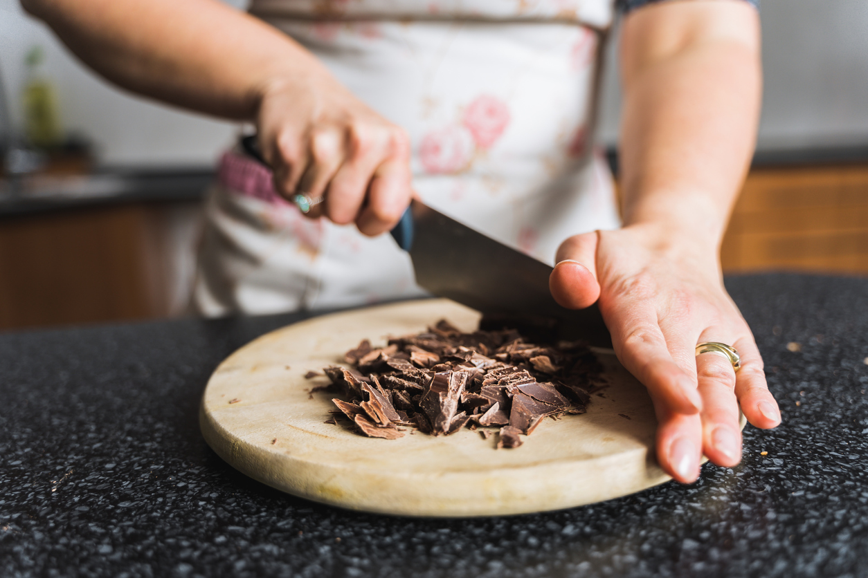 Donna che taglia il cioccolato su un tagliere