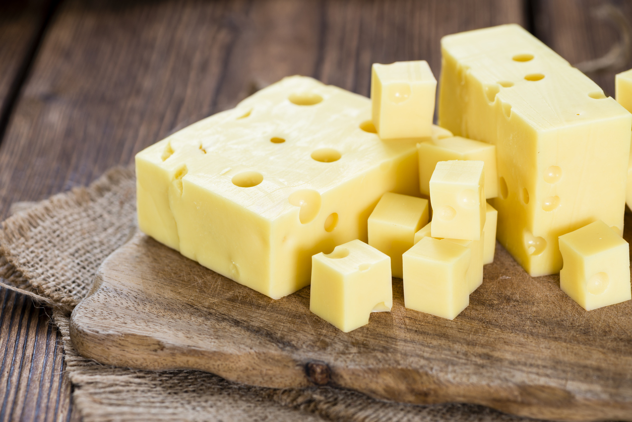 Portion of Cheese (close-up shot) on rustic wooden background