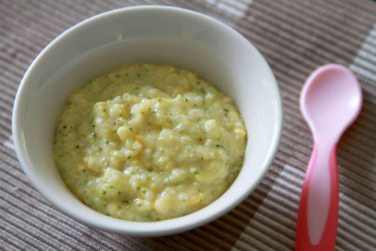 Mashed or puree baby food with pink spoon